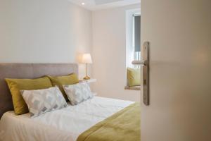 een slaapkamer met een bed met witte lakens en kussens bij Top Alfama Appartment in Lissabon