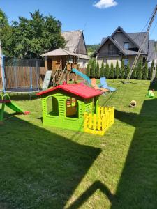 a green and yellow play house on the grass at Apartamenty i Domki Biały Dunajec in Biały Dunajec