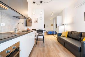 a kitchen and a living room with a couch at A pochi minuti da Fiera Bologna Apartment in Bologna