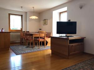 sala de estar con TV y mesa con sillas en Casa Crepaz, en Canal San Bovo