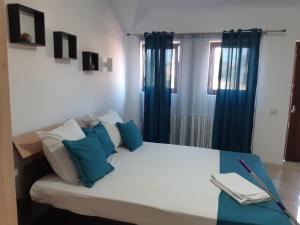 a bedroom with a bed with blue pillows at Vila Amy in Năvodari