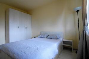 um quarto com uma cama branca e um armário em Gara de Nord - Resedinta lui Calin em Bucareste