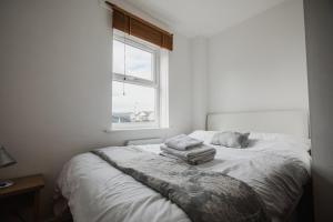 a bedroom with a bed with two towels on it at Hullidays - Victoria Dock Residence in Hull