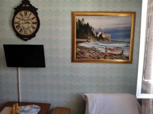 eine Uhr an der Wand mit einem Bild eines Strandes in der Unterkunft Rab-centar in Rab
