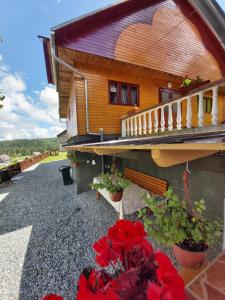 uma casa com flores vermelhas em frente em Casa Geo em Arieşeni