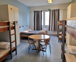 a room with a table and chairs and bunk beds at Godby Vandrarhem in Godby
