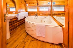 a large tub in a bathroom with wooden floors at Abalone Lodges in Knysna