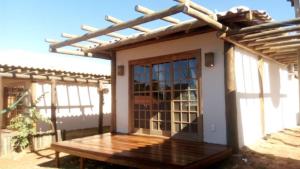 戈亞斯州上帕萊索的住宿－Vila Gaia Guest House，一座带木门廊和门的小房子
