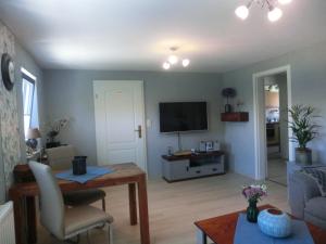 a living room with a couch and a tv at Gästehaus Daheim in Lohme