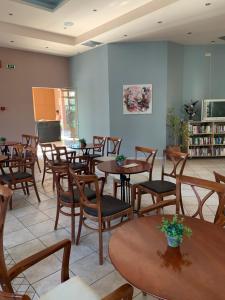a room with tables and chairs and a tv at Georges Estates Hotel in Stoupa