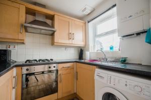 a kitchen with a stove top oven next to a dishwasher at Hullidays - Victoria Dock Residence in Hull