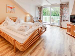 a bedroom with a large bed and a balcony at Hotel Seeschlösschen in Hohwacht