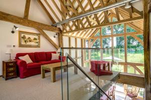 a living room with a red couch and a table at South Park Farm Barn in Andover