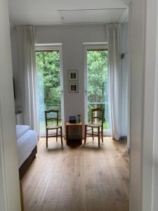une chambre avec deux chaises, un lit et une fenêtre dans l'établissement LandKate Lüdinghausen - 5 Sterne Ferienhaus, à Lüdinghausen