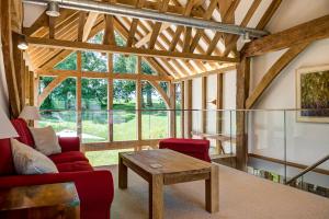 a living room with a red couch and a table at South Park Farm Barn in Andover