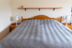 a bed in a room with two lamps on the floor at Apartmán Fraise in Děčín