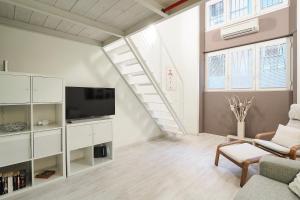 - un salon avec un canapé et une télévision dans l'établissement Contempora Apartments - Breno 2, à Milan