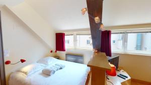 a bedroom with a bed and a desk with a computer at Studio Pelletiers, 4 personnes – City center in Strasbourg