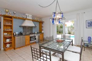 eine Küche und ein Esszimmer mit einem Glastisch und Stühlen in der Unterkunft Villa-Tauro Leyh in Mogán