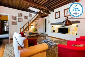 uma sala de estar com mobiliário vermelho e branco e uma escadaria em Casa Villa Garden em Ponta Delgada