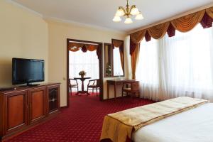 a hotel room with a bed and a flat screen tv at Armenia Hotel in Tula