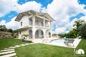 a house with a swimming pool in the yard at Villa Bocciolo, piscina, giardino, vasca idromassaggio in Manerba del Garda
