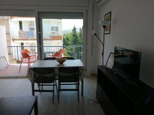 sala de estar con mesa y sillas y balcón en Apartament Passeig Maritim en Llança