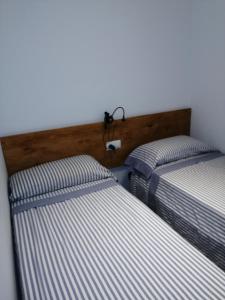 dos camas sentadas una al lado de la otra en una habitación en Apartament Passeig Maritim en Llança