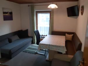 a living room with a table and a couch at Haus Bergfrieden in Achenkirch