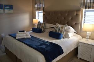 a bedroom with a large bed with two pillows at Caulfield Self Catering Apartment #SOLAR ENERGY - NO LOADSHEDDING in Port Elizabeth