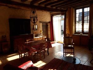 a living room with a table and chairs and a television at Gite rural DUNAND in Tournon-Saint-Martin