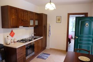 una cocina con armarios de madera y una puerta azul en Agriturismo Il glicine e la lucerna - Appartamento Scala en Ranzo-Borgo