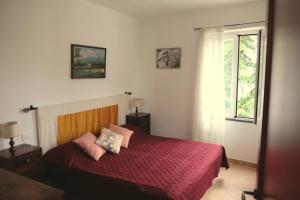 1 dormitorio con cama roja y ventana en Agriturismo Il glicine e la lucerna - Appartamento Scala en Ranzo-Borgo