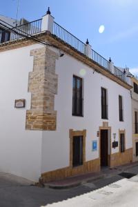 um edifício branco com uma varanda em cima em Hospedium Hostal Temático Desde La Judería em Arjona