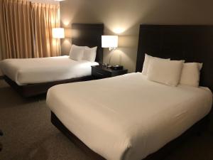 a hotel room with two beds and two lamps at Ramada by Wyndham Lindsay in Lindsay