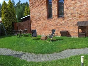 une cour avec des chaises et une table en face d'un bâtiment en briques dans l'établissement Gościniec Silver, à Toruń