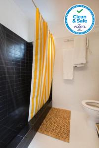 La salle de bains est pourvue d'une douche et de toilettes avec un panneau. dans l'établissement Casa Villa Cottage, à Ponta Delgada