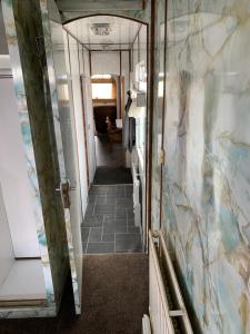 a hallway in a train car with a tile floor at Vintage, Circus Holiday Home in Mablethorpe