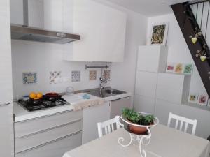 a kitchen with white cabinets and a table with a bowl on it at A casa di Ninuccia in Syracuse