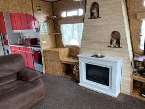 a living room with a fireplace in a tiny house at Vintage, Circus Holiday Home in Mablethorpe