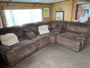 a brown leather couch in a living room at Vintage, Circus Holiday Home in Mablethorpe