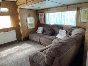 a living room with a large brown couch in a room at Vintage, Circus Holiday Home in Mablethorpe