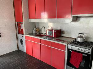 a red kitchen with a stove and a microwave at Vintage, Circus Holiday Home in Mablethorpe
