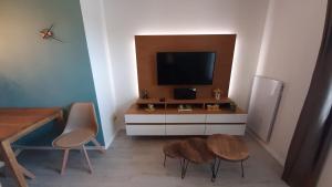 sala de estar con 2 mesas y TV en Apartmán Tatran A 12, en Donovaly