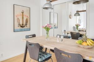 a dining room with a wooden table and chairs at WeHost Tarkk'ampujankatu in Helsinki