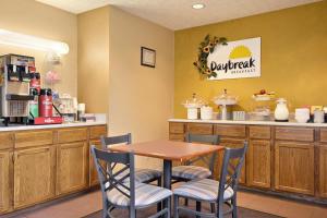 a restaurant with a table and chairs and a counter at Days Inn by Wyndham Plainfield in Plainfield