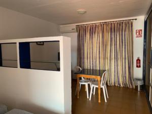 Habitación con mesa, sillas y ventana en Hotel Playa Conil, en Conil de la Frontera