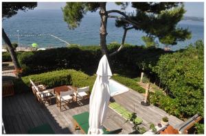 un patio con sombrilla blanca, sillas y el océano en Premium apartment Natura en Izola