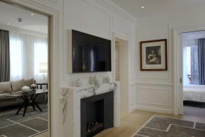 a living room with a fireplace with a tv above it at Lungarno Luxury Apartments - by Lungarno Collection in Florence