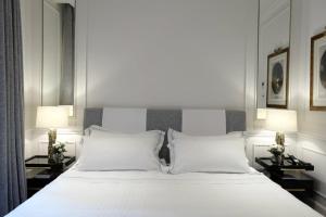 a bedroom with a large white bed with two lamps at Lungarno Luxury Apartments - by Lungarno Collection in Florence